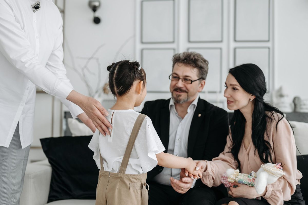 Familie care ține în brațe un copil, simbolizând adopția și grija
