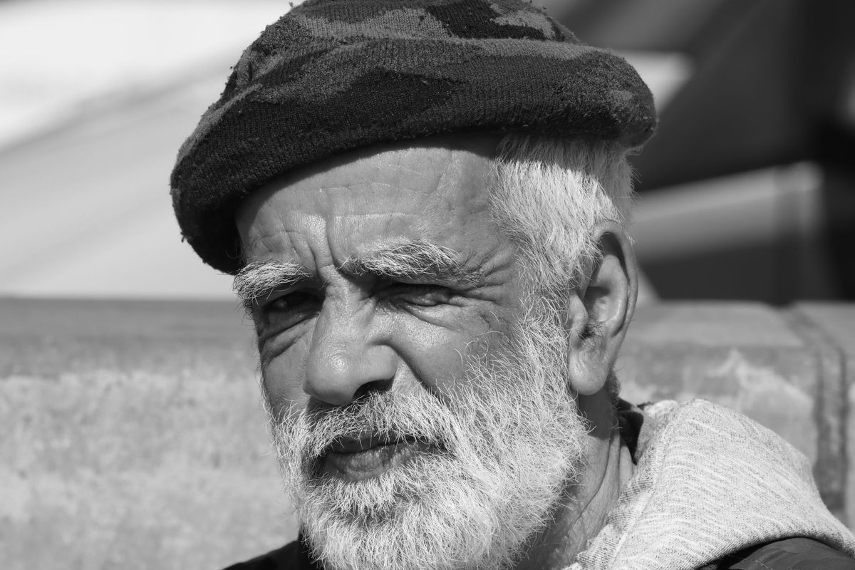 Bărbat cu păr alb privind în depărtare, simbol al înțelepciunii câștigate