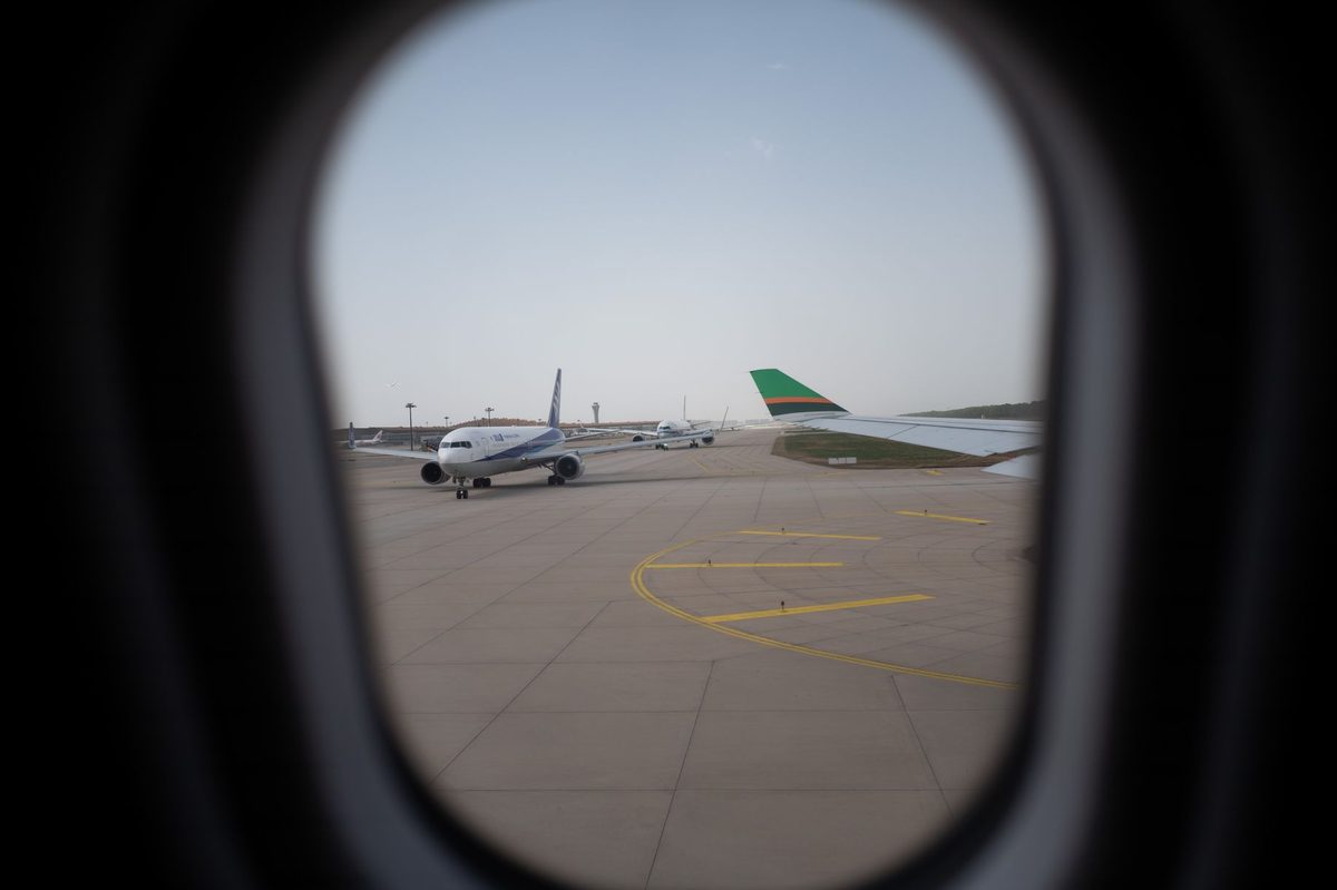 Pasager alergând spre poarta de îmbarcare în aeroport, simbolizând anxietatea de a pierde avionul