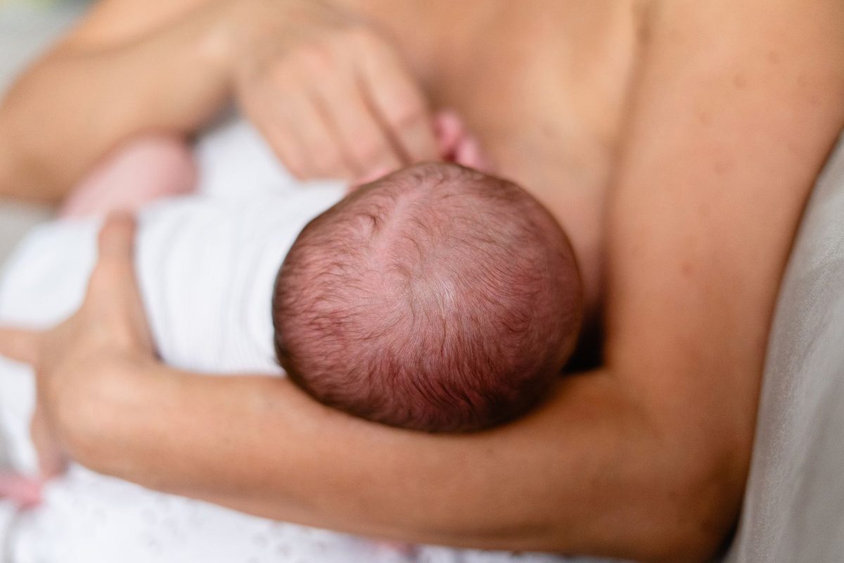 mamă alăptând un nou-născut, simbol al dăruirii și al legăturii