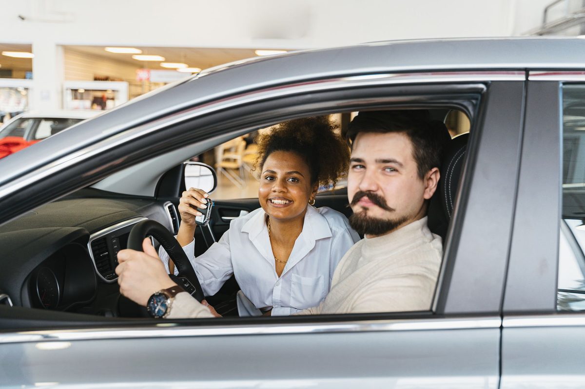 Persoane într-o mașină pe drum în călătorie după obținerea permisului auto