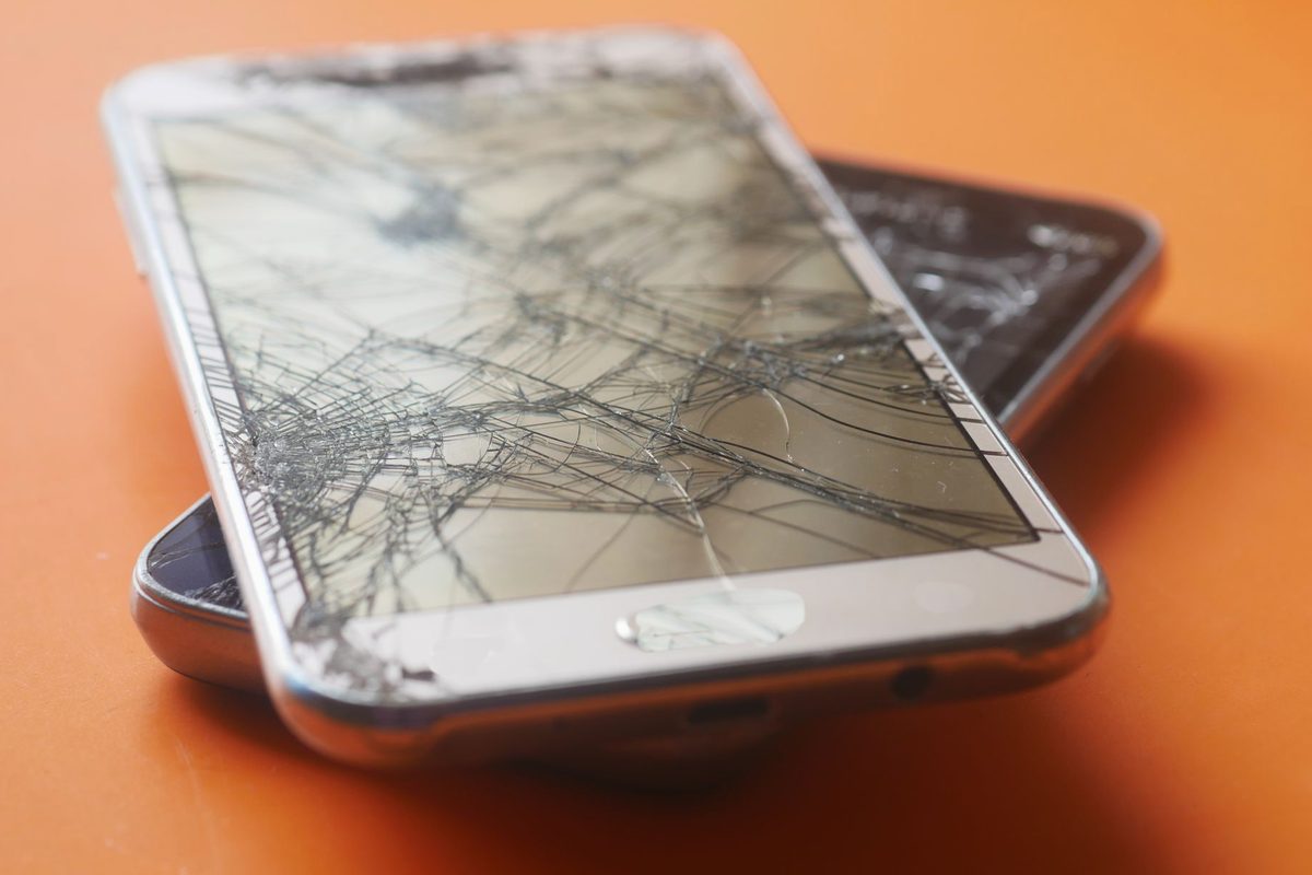 Ecran de telefon spart cu crăpături de sticlă, simbolizând dificultățile de comunicare din vis