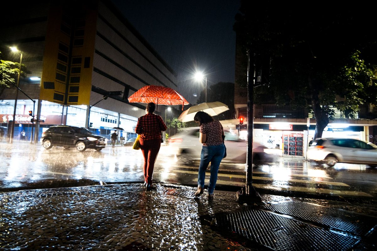 Prognoză meteo cu probabilitate de precipitații și o persoană cu umbrelă pe stradă