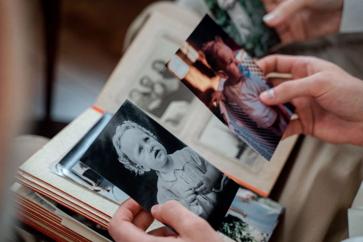 Persoană privind o fotografie veche cu amintiri de familie