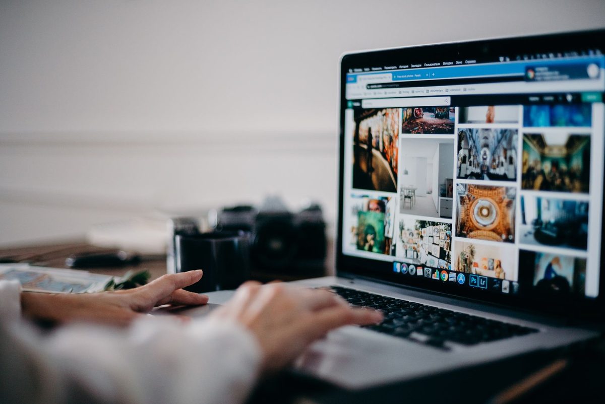 Persoană care citește un site pe laptop și se uită la un buton de pe pagină