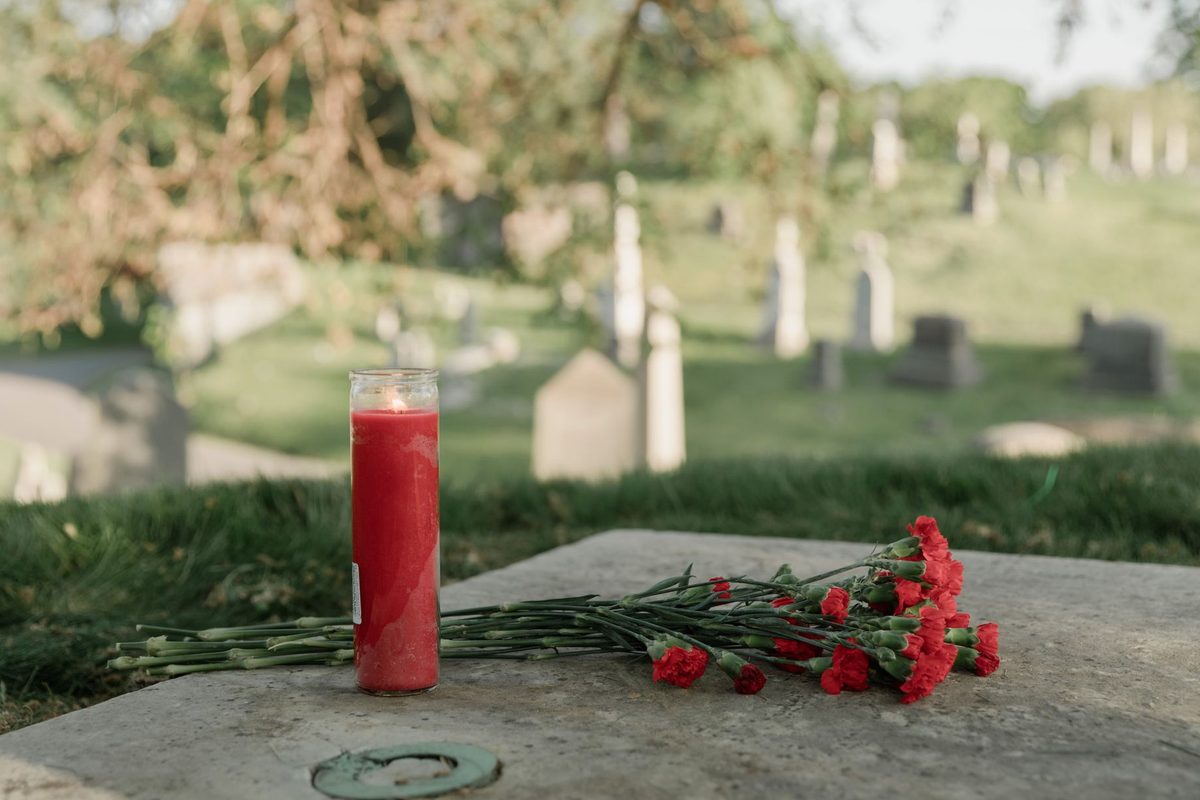 Lumânare aprinsă într-un cimitir, simbol al comemorării