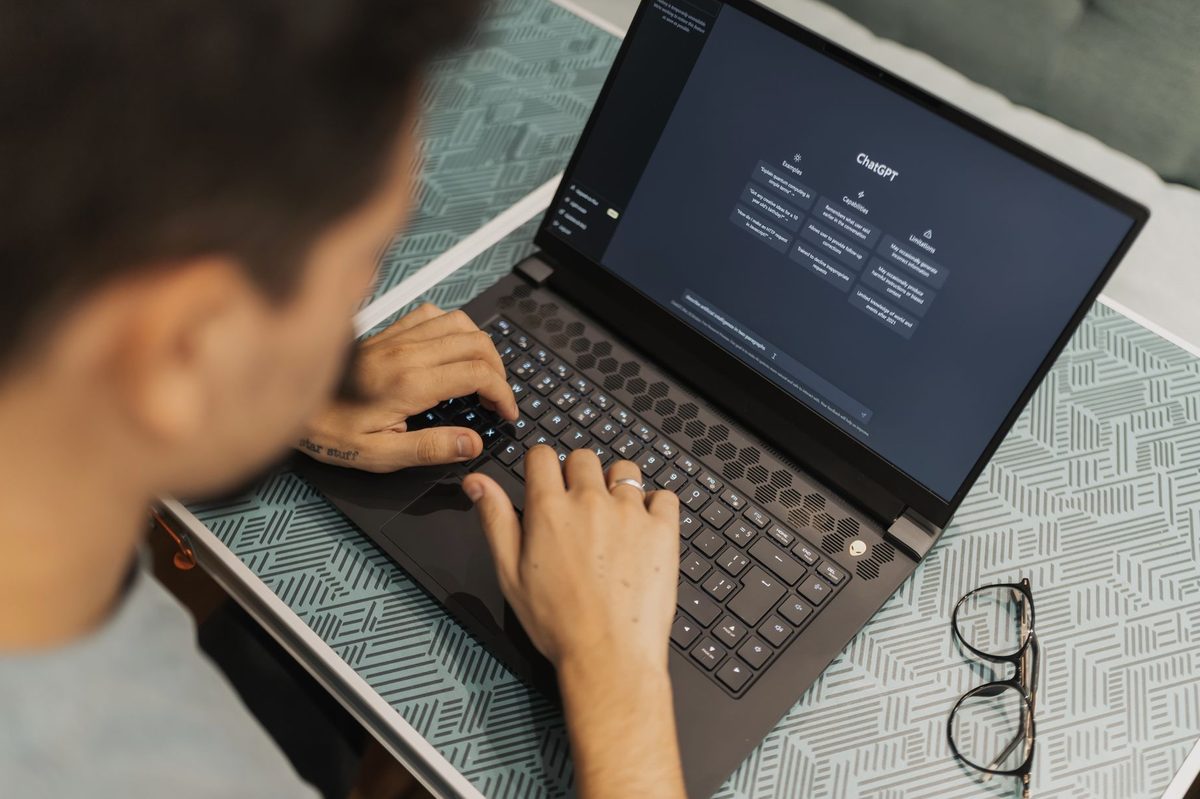 Persoană care folosește un chatbot cu inteligență artificială pe laptop