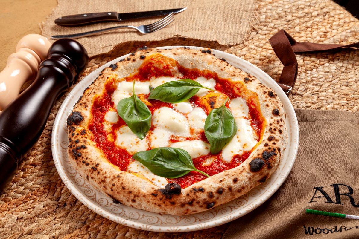 Pizza napoletană coaptă într-un cuptor cu lemne