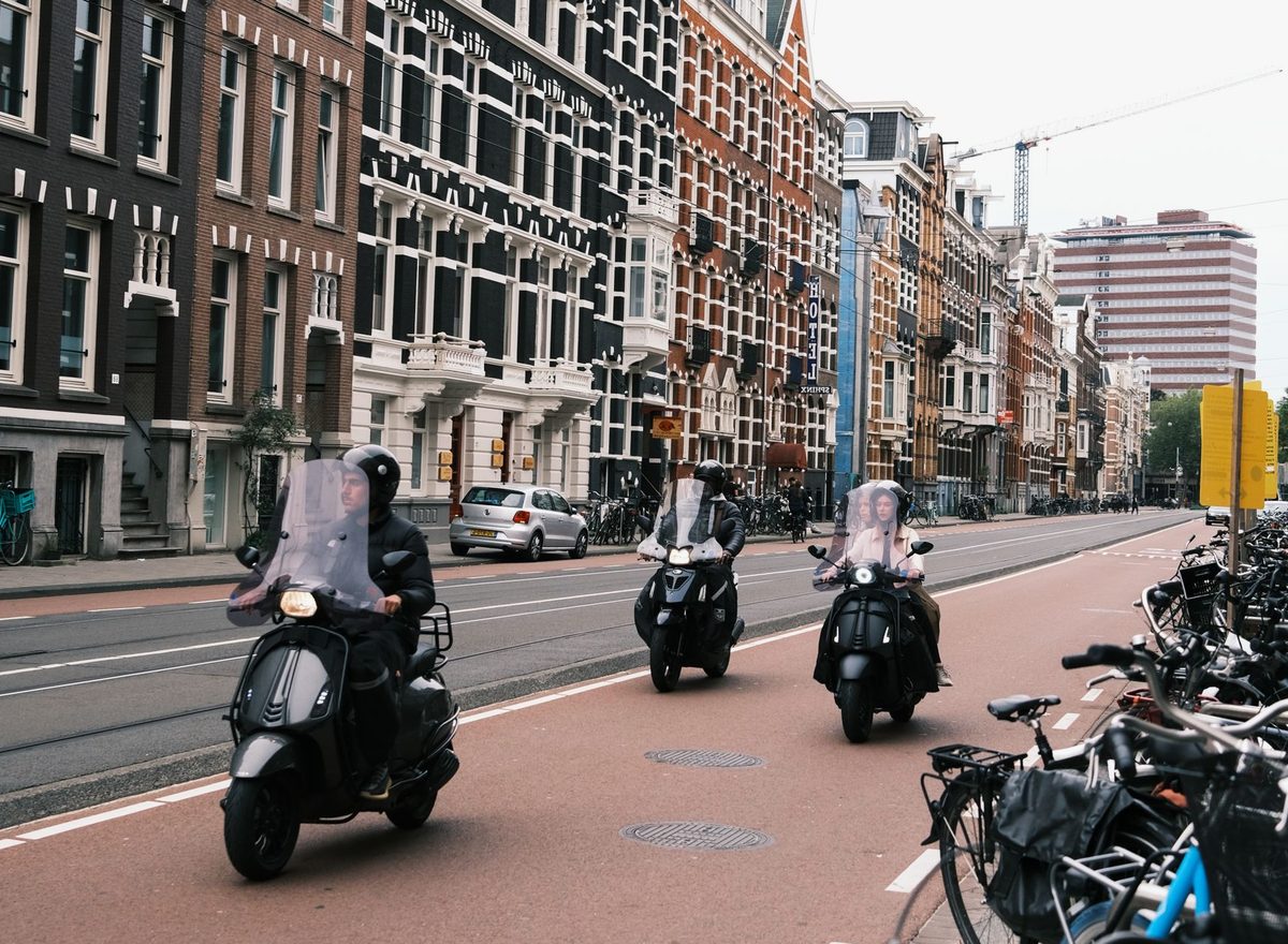 Moped condus în traficul urban pe o stradă aglomerată