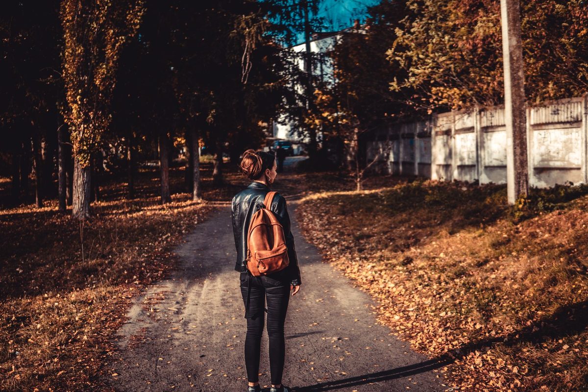Persoană mergând pe jos pe un drum, simbol al progresului prin efort propriu în vis