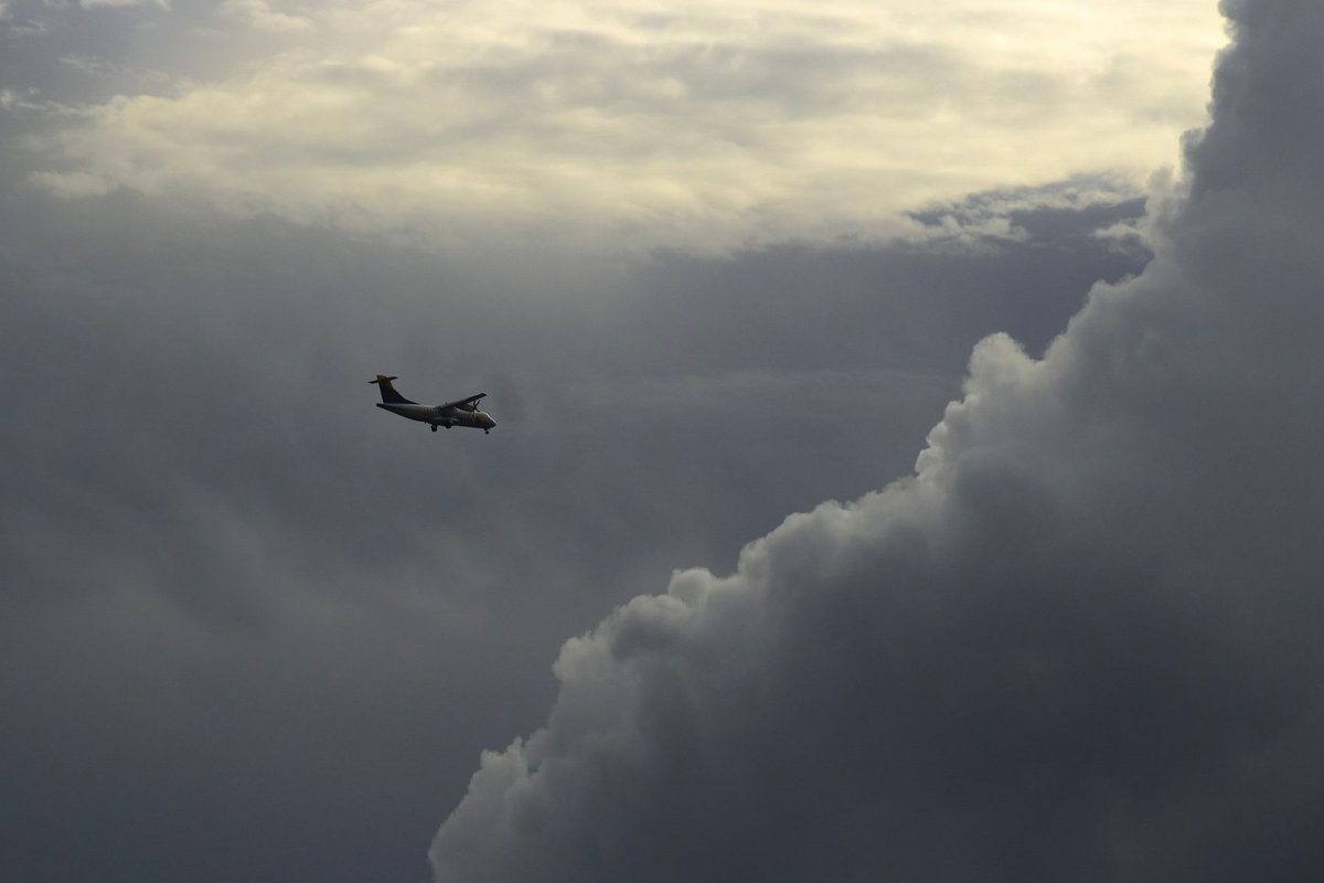 Avion zburând printre nori întunecați de furtună, simbol pentru frica de prăbușire și pierderea controlului