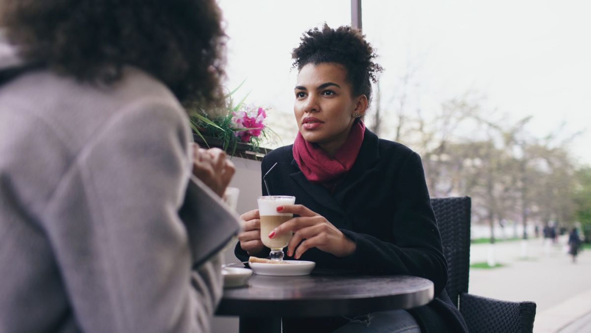 Doi prieteni discută într-o atmosferă caldă la o cafenea