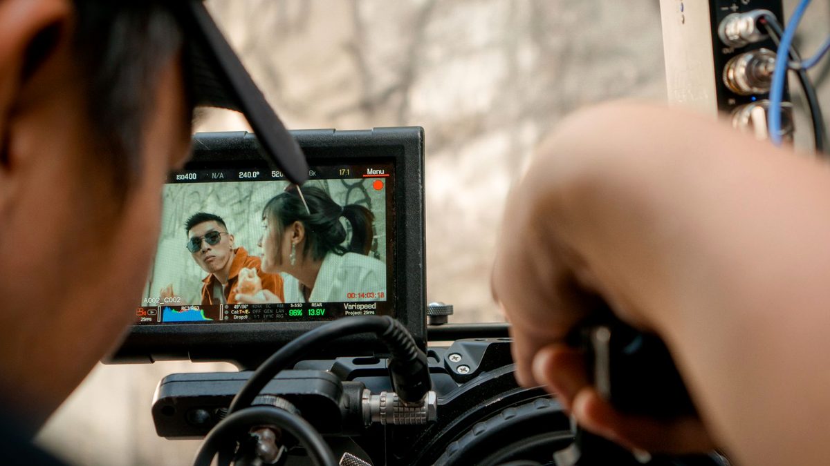 Monitor de film pe un platou, cu membri ai echipei în afara cadrului