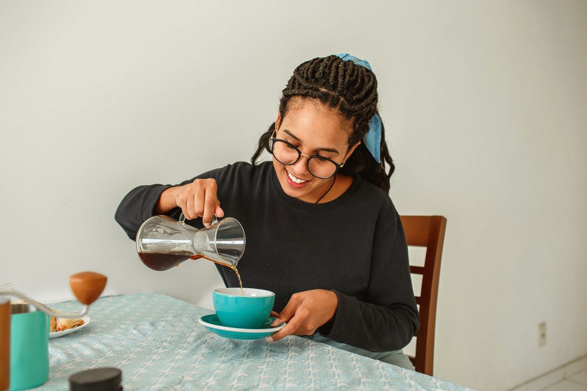 Cafea turnată într-o ceașcă, la masă