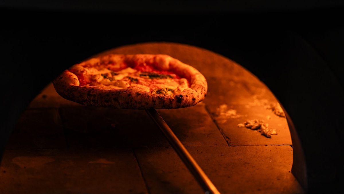 Pizza napoletană coaptă într-un cuptor cu lemne