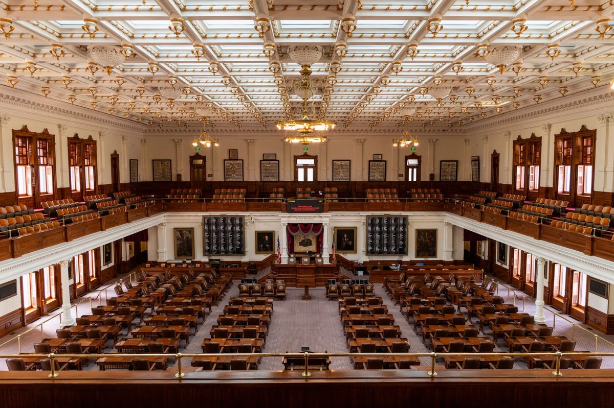Sală legislativă goală, scaune și balcon, atmosferă tensionată