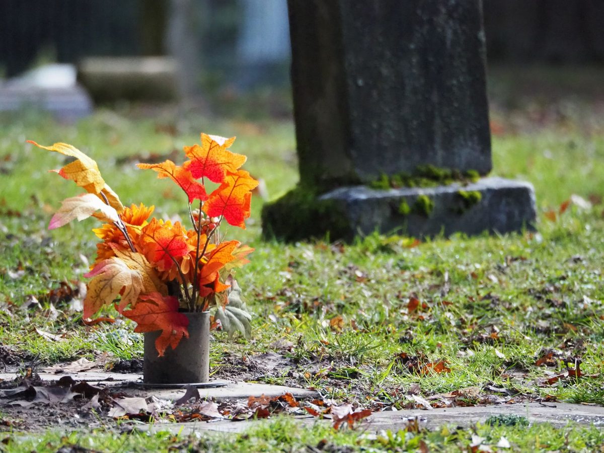 Flori și pietre funerare într-un cimitir
