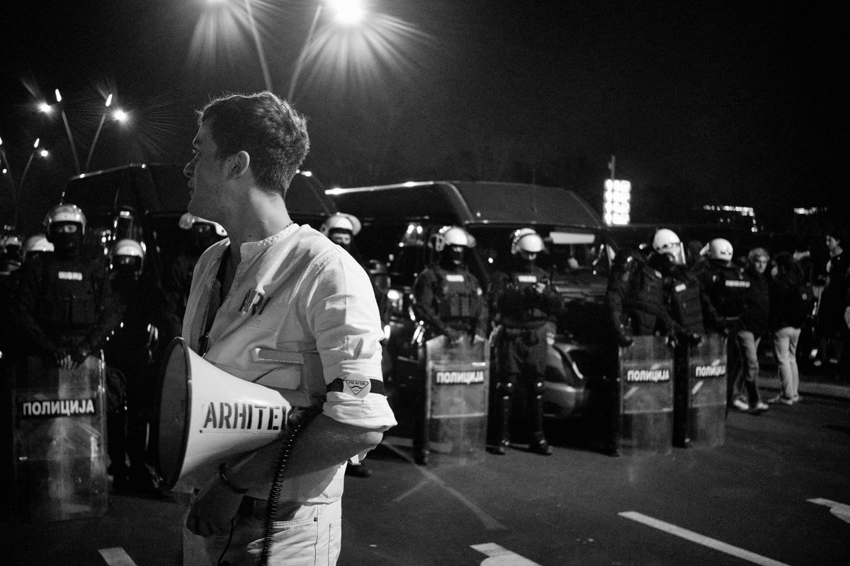 Persoană cu megafon la un protest pe stradă, energie zgomotoasă