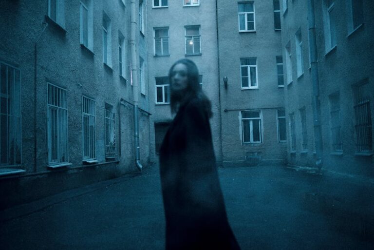 Siluetă misterioasă și neclară într-un cadru urban cetoș, evocând atmosfera viselor cu străini necunoscuți