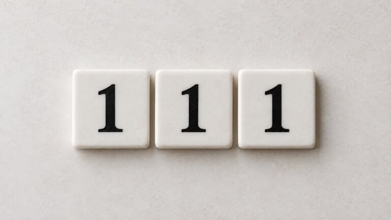 Trei plăcuțe ceramice albe, fiecare cu cifra 1, formează numărul 111 pe un fundal crem.