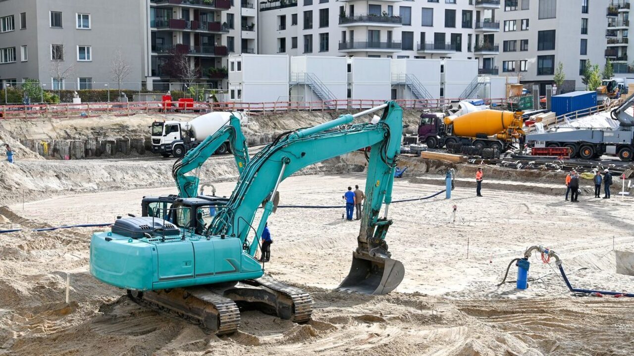 Utilaje de construcții și autobetoniere pe șantierul unei fundații de mari dimensiuni.