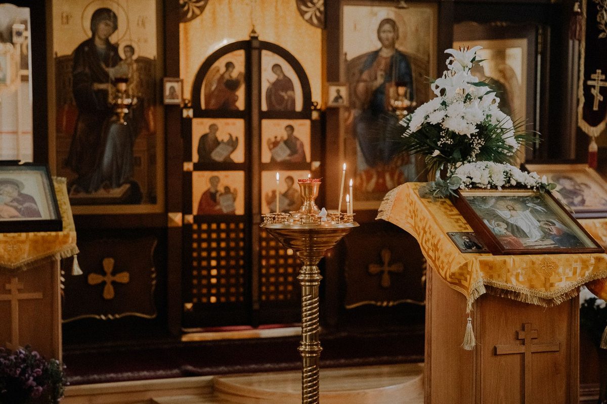 Pelerini și lumânări la o biserică ortodoxă