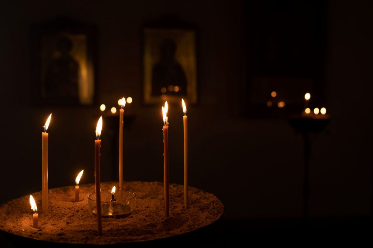 Lumânări aprinse lângă icoană în biserică ortodoxă
