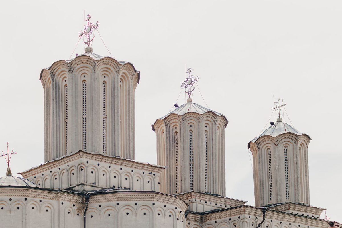 Cruce ortodoxă lângă o biserică toamna