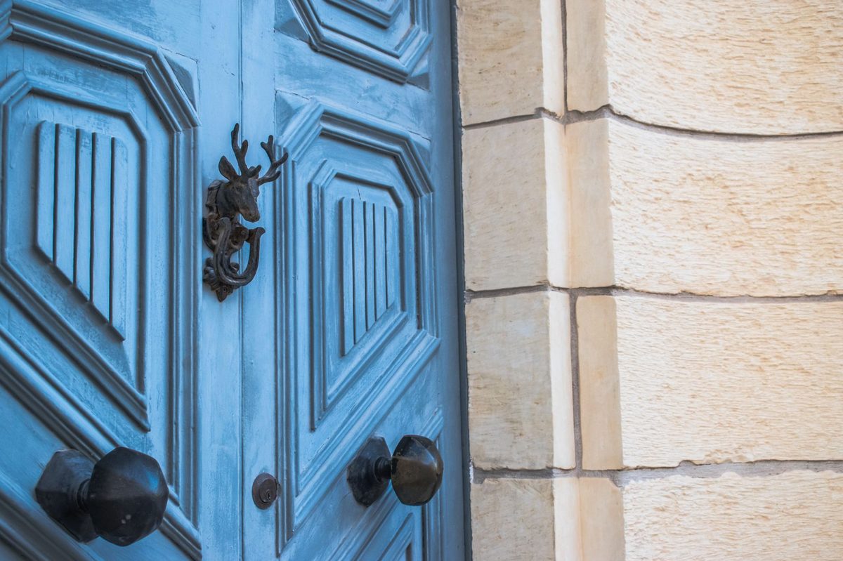 Ușă de lemn cu ciocan decorativ la intrarea unei case