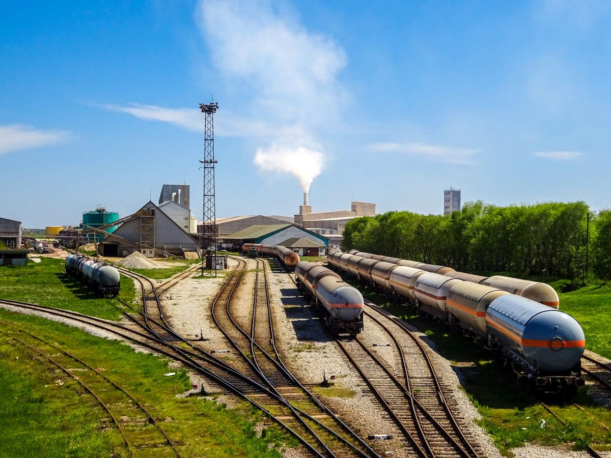 Praf și fum ridicându-se pe un teren industrial gol