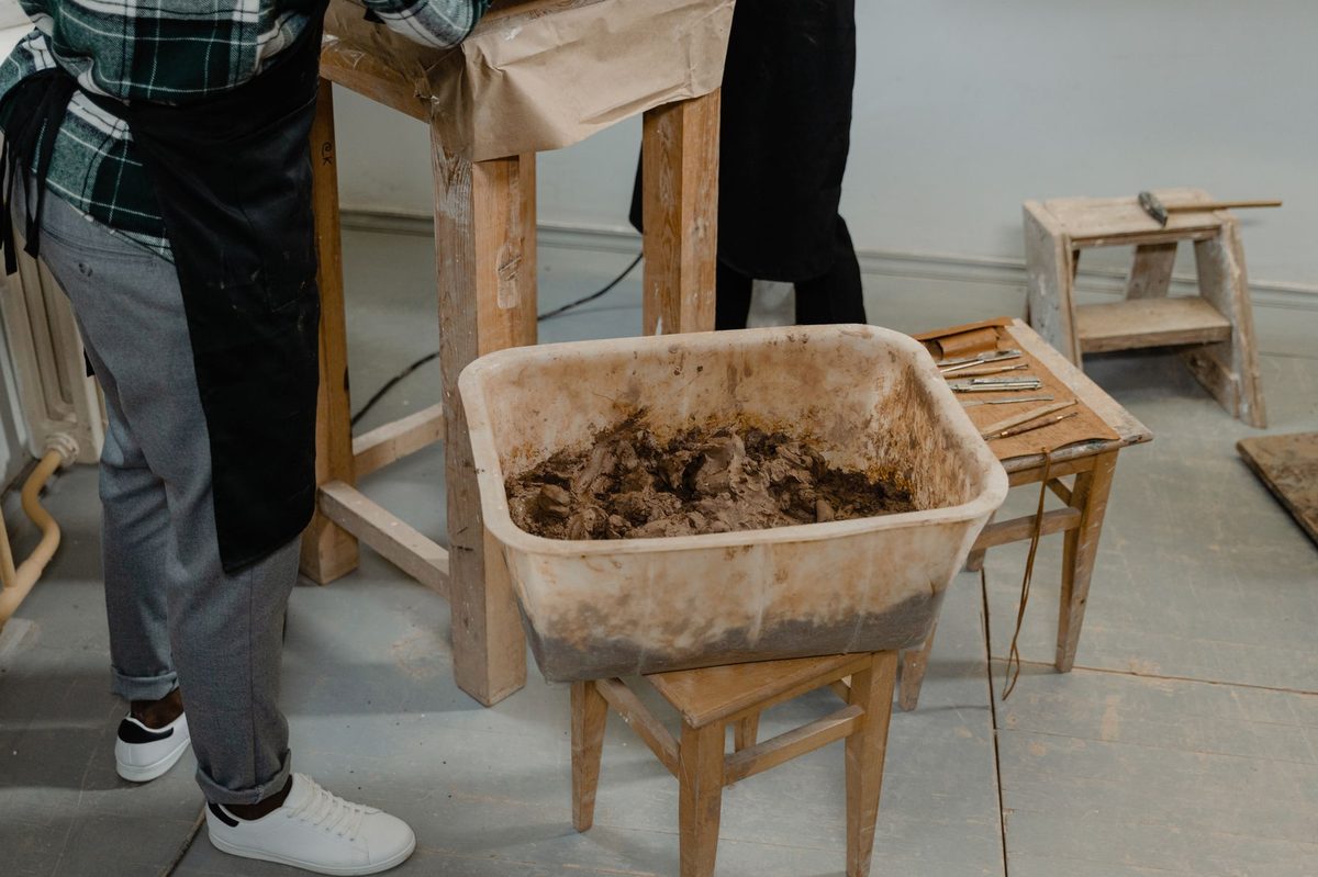 Mâini lucrând lut umed într-un atelier de ceramică