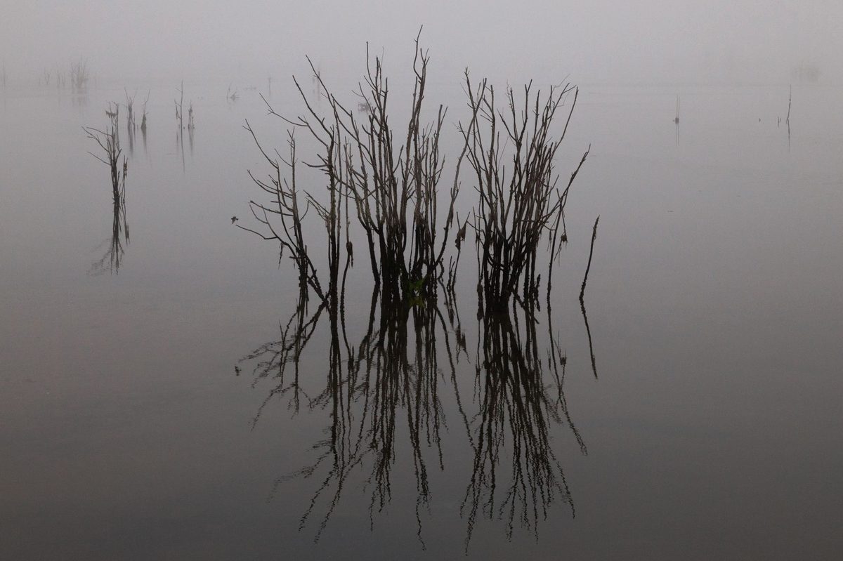 Suprafață de apă liniștită reflectând cerul într-un cadru de introspecție