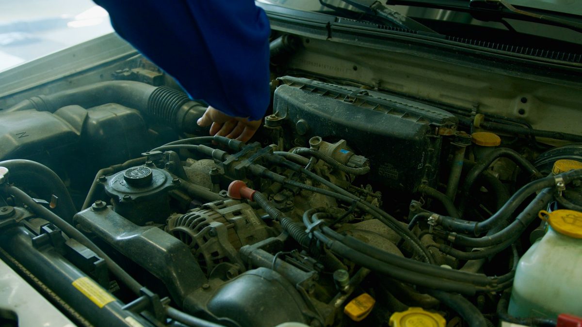 Mecanic auto verificând motorul unui vehicul în service