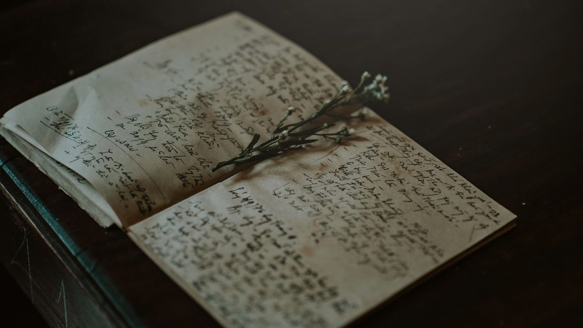 Jurnal deschis cu coperți din piele pe o masă rustică