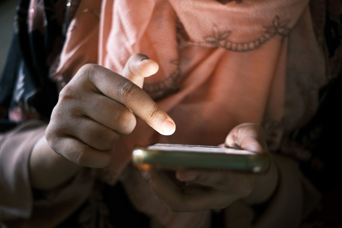 Persoană care derulează pe telefon în transportul public