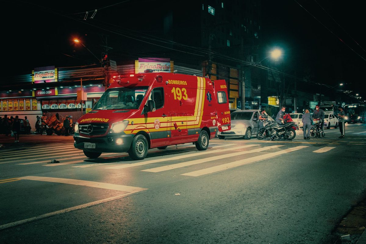 Ambulanță cu girofaruri pe un drum de noapte