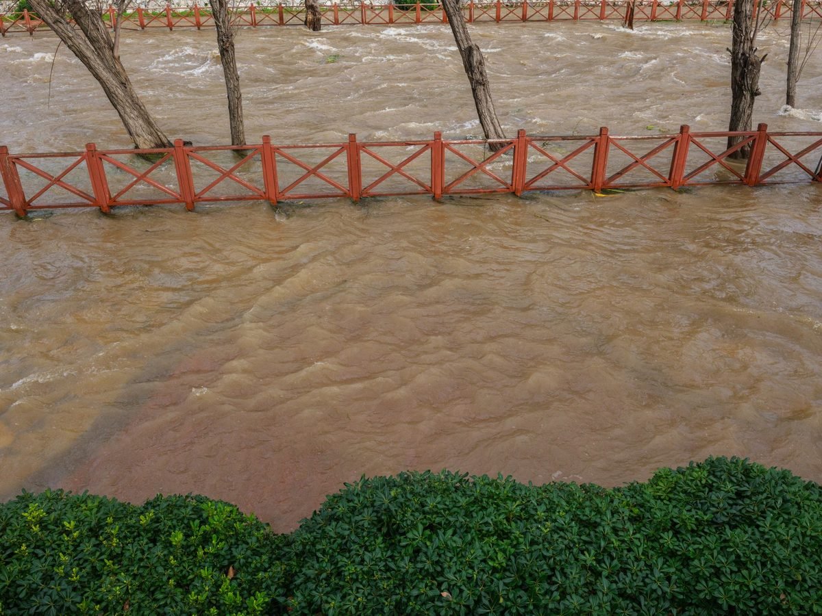 Apă murdară și noroioasă care acoperă o promenadă după o inundație