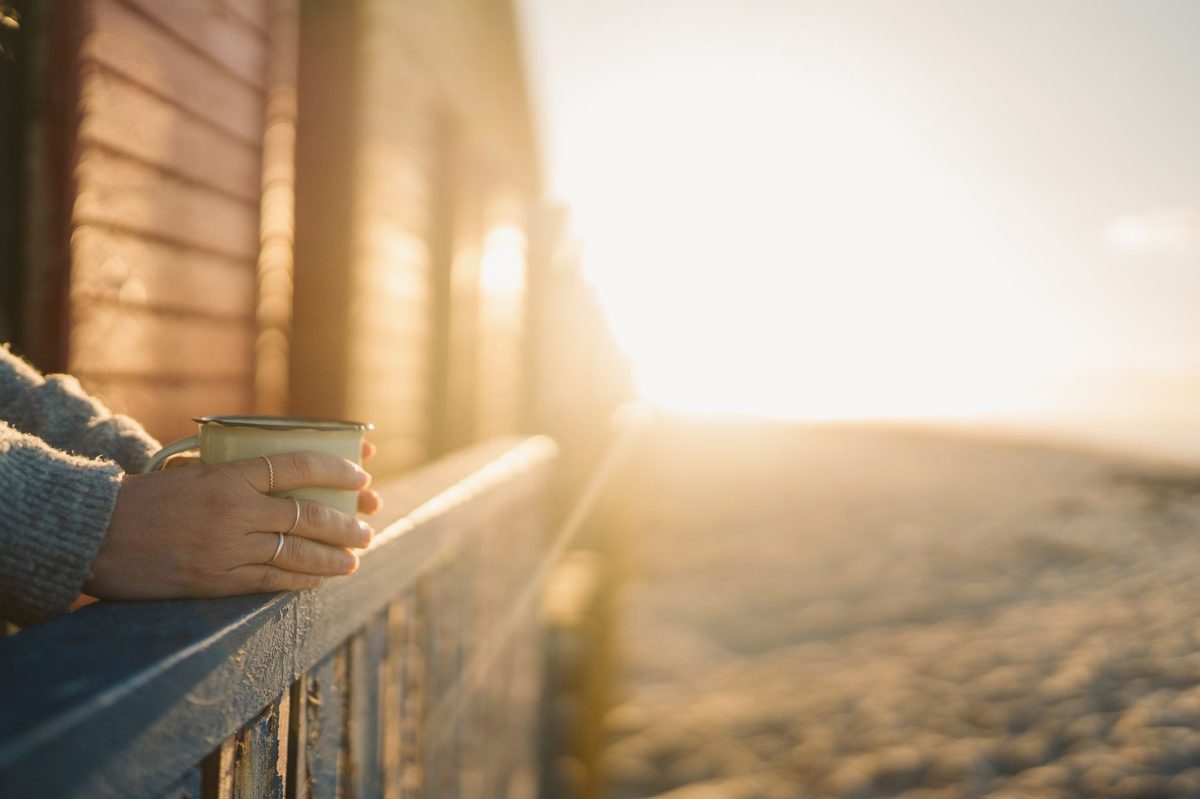 Dimineață liniștită cu cafea la fereastră, în lumină caldă