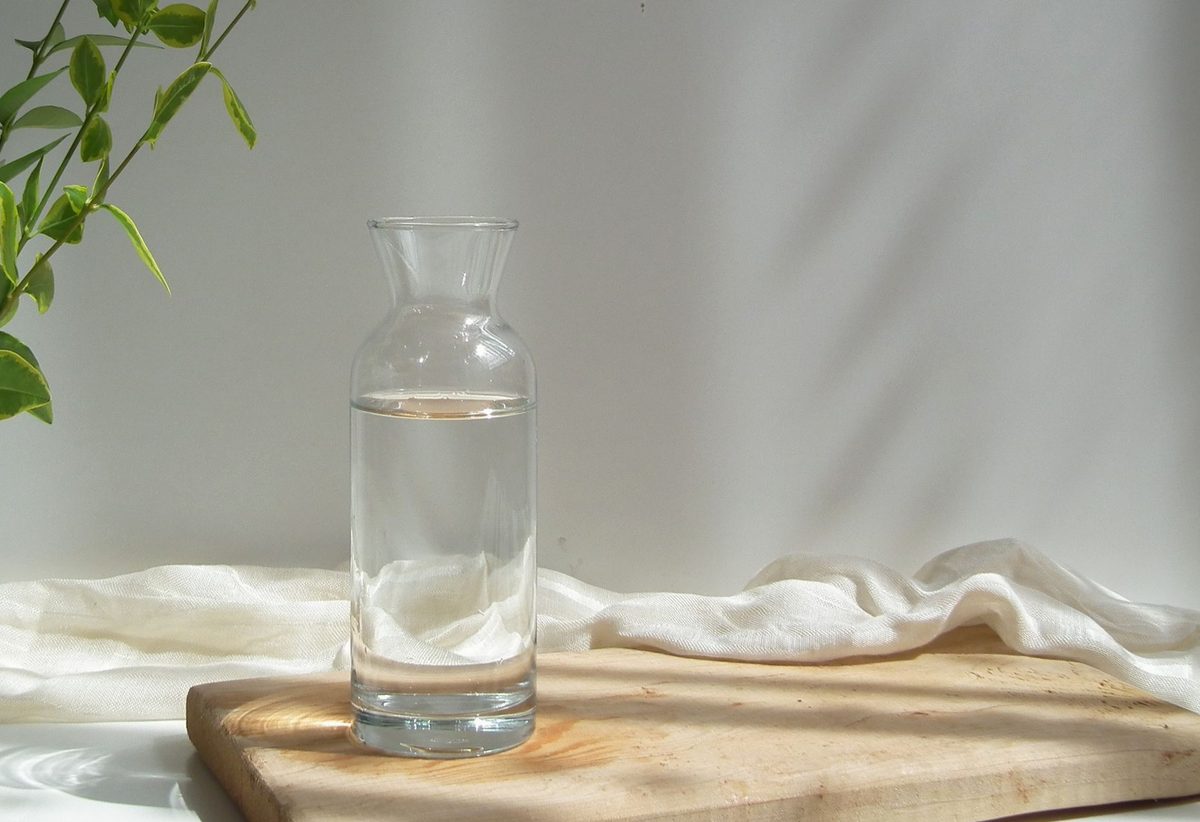 Carafă de sticlă cu apă pe masă de lemn