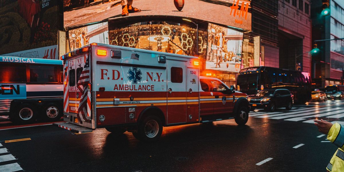 Ambulanță cu girofaruri pe un drum de noapte
