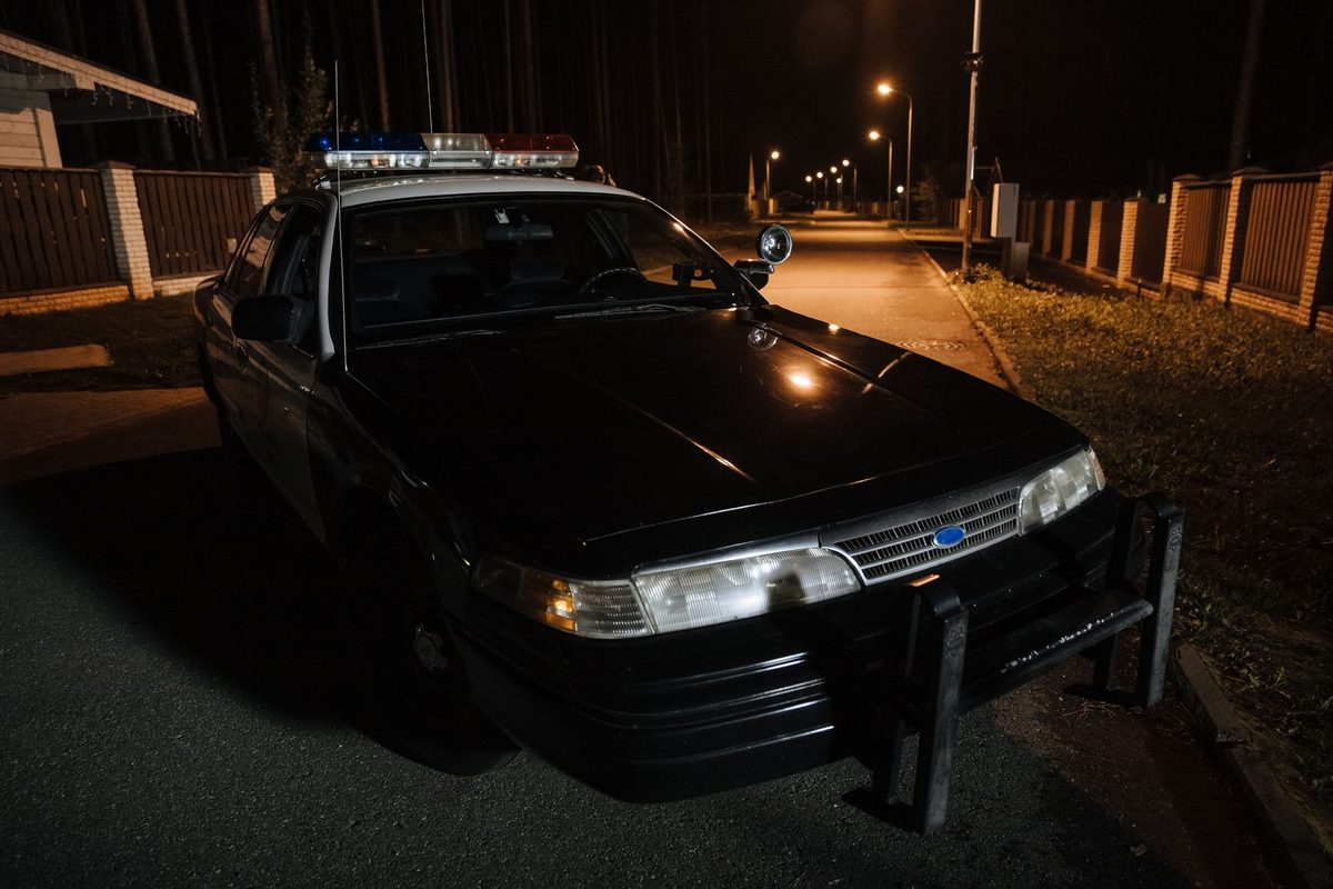 Mașină de poliție cu girofaruri aprinse noaptea